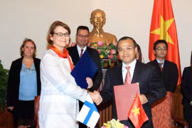 Thứ trưởng Ngoại giao Vũ Hồng Nam và Thứ trưởng Ngoại giao Phần Lan Pirkko Hamalainen thực hiện lễ ký. (Ảnh: An Đăng/TTXVN)