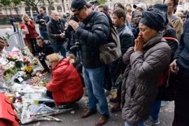 Người dân đặt hoa thắp nến gần Nhà hát Bataclan ở thủ đô Paris, một trong những nơi xảy ra các vụ tấn công khủng bố. (Nguồn: Kyodo/TTXVN)