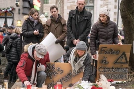 Người dân Canada thắp nến tưởng niệm các nạn nhân vụ tấn công khủng bố ở Pháp bên ngoài Lãnh sự quán Pháp ở thành phố Quebec. (Nguồn: AFP/TTXVN)