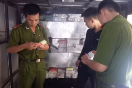 Lực lượng công an đang kiểm tra nguồn gốc xuất xứ số điện thoại di động thu giữ trên ôtô tải BKS 14C-134.37. (Ảnh: Thái Hùng/TTXVN)