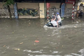 Tại đường Điện Biên Phủ, các phương tiện di chuyển khó khăn vì nước ngập cao gần bằng bánh xe. (Ảnh: Phạm Kiên/TTXVN)