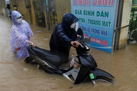Nhiều nơi nước ngập hơn nửa thân xe máy. (Ảnh: Lê Ngọc Phước/TTXVN)