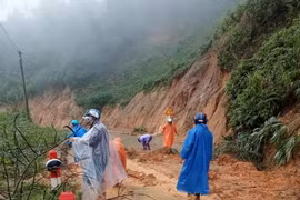 Các lực lượng xung kích và người dân địa phương dọn dẹp đất đá bị sạt lở trên các tuyến đường liên xã Trà Vân-Trà Cang, huyện Nam Trà My, tỉnh Quảng Nam. (Ảnh: Đoàn Hữu Trung/TTXVN)
