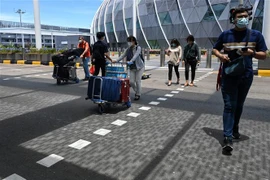 Hành khách đeo khẩu trang phòng dịch COVID-19 tại sân bay quốc tế Changi, Singapore. (Ảnh: AFP/TTXVN)