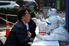Nhân viên y tế lấy mẫu xét nghiệm COVID-19 cho người dân tại Bắc Kinh, Trung Quốc. (Ảnh: AFP/TTXVN)