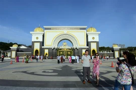 Khách du lịch chụp ảnh trước Cung Hoàng gia Malaysia tại Kuala Lumpur. (Ảnh: THX/TTXVN)