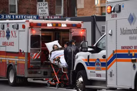 Nhân viên y tế chuyển bệnh nhân COVID-19 tới trung tâm y tế ở New York, Mỹ. (Ảnh: AFP/TTXVN)