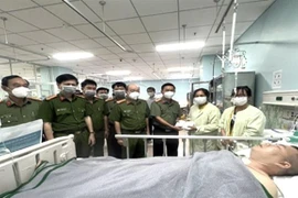 Đại tá Trần Tiến Đạt, Phó giám đốc Công an tỉnh Đồng Nai tặng quà và thăm hỏi đại diện gia đình đại úy Nguyễn Thế Đức. (Ảnh: TTXVN phát)