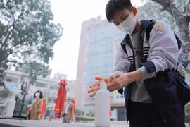 Học sinh lớp 12 trường THPT Kim Liên, quận Đống Đa thực hiện sát khuẩn tay khi tới trường học trực tiếp từ sáng 4/1/2022. (Ảnh: Thanh Tùng/TTXVN)