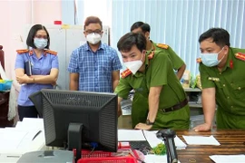 Lực lượng chức năng khám xét nơi làm việc của bị can Vũ Thái An. (Ảnh: TTXVN phát)