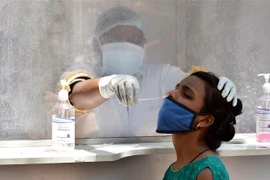 Nhân viên y tế lấy mẫu xét nghiệm COVID-19 cho người dân tại Hyderabad, Ấn Độ. (Ảnh: THX/TTXVN)