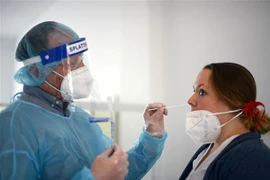 Nhân viên y tế lấy mẫu xét nghiệm COVID-19 tại Hagen, miền Tây Đức. (Ảnh: AFP/TTXVN)