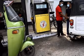 Nhân viên đổ xăng cho xe ôtô tại một trạm xăng dầu ở Colombo ngày 18/2. (Ảnh: AFP)