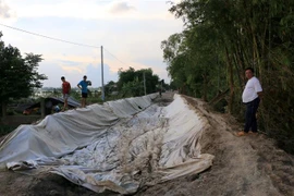 Nhiều người dân địa phương bức xúc vì nền đường Kháng Chiến (bờ nam) thi công dang dở khiến việc đi lại khó khăn. (Ảnh: Nhựt An/TTXVN)