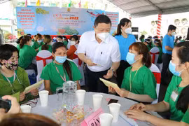 Ông Dương Anh Đức, Phó Chủ tịch UBND Thành phố Hồ Chí Minh chúc Tết và trao quà cho công nhân lao động có hoàn cảnh khó khăn, không có điều kiện về quê đón Tết tại Công ty trách nhiệm hữu hạn Lạc Tỷ, quận Bình Tân, TP Hồ Chí Minh. (Ảnh: Thanh Vũ/TTXVN)