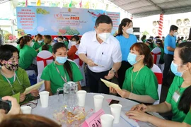 Ông Dương Anh Đức, Phó Chủ tịch UBND Thành phố Hồ Chí Minh chúc Tết và trao quà cho công nhân lao động có hoàn cảnh khó khăn, không có điều kiện về quê đón Tết tại Công ty trách nhiệm hữu hạn Lạc Tỷ, quận Bình Tân, TP Hồ Chí Minh. (Ảnh: Thanh Vũ/TTXVN)