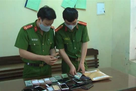 Công an Thanh Hóa và tang vật của một vụ án đánh bạc. (Ảnh TTXVN phát)