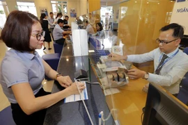 Khách hàng giao dịch tại Ngân hàng Bảo Việt chi nhánh Gia Lai. (Ảnh: Trần Việt/TTXVN)