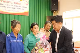 Đại diện doanh nghiệp tặng quà Tết cho người dân. (Ảnh: Tuấn Anh/TTXVN)