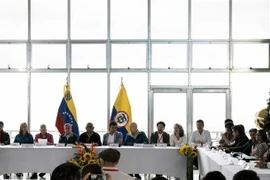 Các thành viên phái đoàn Chính phủ Colombia (phải) và nhóm vũ trang Quân đội Giải phóng Quốc gia (ELN - trái) tại cuộc họp báo sau vòng đàm phán hòa bình ở Caracas, Venezuela, ngày 21/11/2022. (Ảnh: AFP/TTXVN)