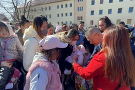 Bà con nhận quà hỗ trợ tại Trung tâm tiếp nhận người tị nạn Eisenhüttenstadt. (Ảnh: Mạnh Hùng/TTXVN)