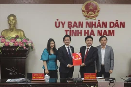 Chủ tịch UBND tỉnh Hà Nam Trương Quốc Huy trao giấy chứng nhận đăng ký đầu tư Dự án đầu tư xây dựng cơ sở giáo dục và đào tạo cho đại điện tập đoàn FPT. (Ảnh: Thanh Tuấn/TTXVN)