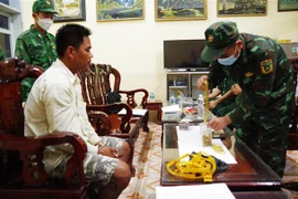 Đối tượng Chau Rít Mây cùng tang vật khi bị bắt giữ. (Ảnh: TTXVN phát)