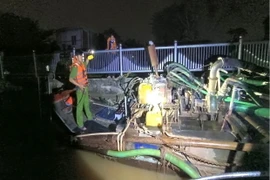 Lực lượng Cảnh sát giao thông phối hợp với lực lượng Cảnh sát môi trường bắt giữ phương tiện bơm hút cát trái phép. (Ảnh: TTXVN phát)