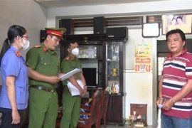 Đối tượng Phan Văn Tài nghe Cơ quan cảnh sát điều tra Công an huyện Phú Tân tiến hành tống đạt các Quyết định liên quan đến vụ án. (Ảnh: TTXVN phát)