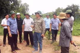Chủ tịch UBND tỉnh Cà Mau Huỳnh Quốc Việt (áo xanh, trái) lắng nghe ý kiến của ngành chức năng về việc đầu tư, hoàn thiện một dự án tái định cư cho người dân ven biển Tây. (Ảnh: Huỳnh Anh/TTXVN)