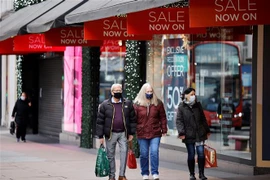 Người dân di chuyển trên một phố mua sắm ở London, Anh. (Ảnh: AFP/TTXVN)
