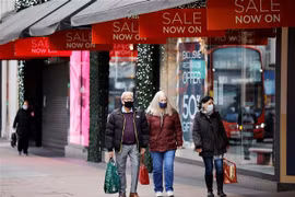 Người dân di chuyển trên một phố mua sắm ở London, Anh. (Ảnh: AFP/TTXVN)