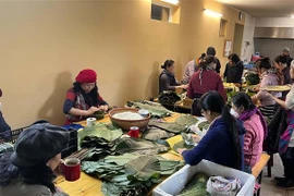 Các phật tử tập trung gói bánh chưng tại Chùa Phổ Đà ở thủ đô Berlin, CHLB Đức. (Ảnh: Mạnh Hùng/TTXVN)