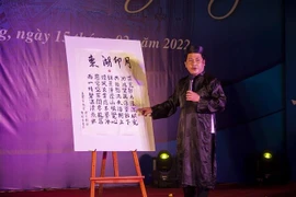 Dịch giả Trần Hót Lái giới thiệu nguyên tác chữ Hán bài thơ “Đông Hồ ấn nguyệt”, một tác phẩm xuất sắc trong chùm thơ Hà Tiên thập vịnh của Mạc Thiên Tích. (Ảnh: Hồng Đạt/TTXVN) 