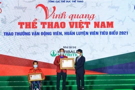 Thứ trưởng Bộ VH, TT và DL Hoàng Đạo Cương trao Huân chương Lao động hạng Nhì, Ba cho vận động viên Lê Văn Công và huấn luyện viên Lê Quang Thái. (Ảnh: Tuấn Anh/TTXVN)