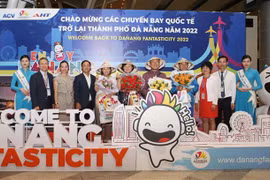 Lãnh đạo Sở Du lịch thành phố Đà Nẵng và Công ty Cổ phần Đầu tư và Khai thác ga quốc tế AHT tặng hoa, quà chúc mừng những vị khách đầu tiên trên đường bay trực tiếp mới mở lại đến Đà Nẵng của hãng hàng không Korean Air. (Ảnh: Trần Lê Lâm/TTXVN)