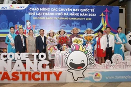 Lãnh đạo Sở Du lịch thành phố Đà Nẵng và Công ty Cổ phần Đầu tư và Khai thác ga quốc tế AHT tặng hoa, quà chúc mừng những vị khách đầu tiên trên đường bay trực tiếp mới mở lại đến Đà Nẵng của hãng hàng không Korean Air. (Ảnh: Trần Lê Lâm/TTXVN)
