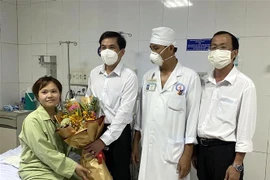 Lãnh đạo Bệnh viện Đa khoa Sóc Trăng tặng hoa chúc mừng bênh nhân đã hồi phục. (Ảnh: TTXVN phát)