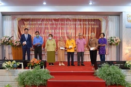 Thứ trưởng Phạm Quang Hiệu (ngoài cùng, trái sang) tặng quà cho các hội đoàn người Việt cùng một số kiều bào có công, kiều bào lão thành. (Ảnh: Hữu Kiên/TTXVN)