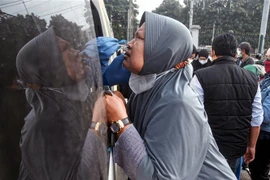 Nhân viên y tế lấy mẫu xét nghiệm COVID-19 cho người dân tại Bekasi, Indonesia. (Ảnh: AFP/TTXVN)