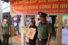  Đại tá Nguyễn Văn Hiểu, Giám đốc Công an tỉnh Đồng Tháp, trao quyết định của Bộ trưởng Bộ Công an thăng cấp bậc hàm từ Đại úy lên Thiếu tá đối với đồng chí Hồ Tấn Dương. (Ảnh: Nhựt An/TTXVN)