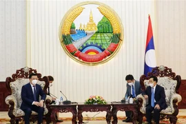 Tổng Bí thư - Chủ tịch nước Lào Thongloun Sisulith tiếp Bí thư Thành ủy Hà Nội Đinh Tiến Dũng. (Ảnh: Phạm Kiên/TTXVN)