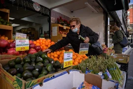 Khách hàng chọn mua hàng tại một quầy bán hoa quả ở New York, Mỹ. (Ảnh: AFP/TTXVN)