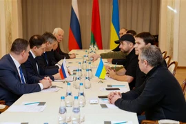 Các thành viên phái đoàn Nga (trái) và Ukraine tại vòng đàm phán ở vùng Gomel, Belarus, ngày 28/2/2022. (Ảnh: AFP/TTXVN)