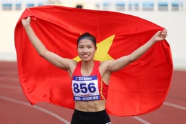 Niềm vui của VĐV Nguyễn Linh Na bên lá quốc kỳ Việt Nam khi giành Huy chương Vàng SEA Games 31. (Ảnh: Quốc Khánh/TTXVN)