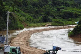 Công ty TNHH 87 tự ý dùng phương tiện cơ giới mở lòng đường ra giữa sông để tiến hành khai thác cát ở thôn 7, xã Đăk Pxi, huyện Đăk Hà, tỉnh Kon Tum. (Ảnh: Cao Nguyên/TTXVN)