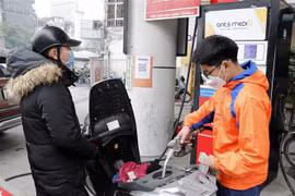 Mua bán xăng dầu tại một điểm kinh doanh xăng dầu trên đường Trần Khát Trân, quận Hai Bà Trưng, Hà Nội. (Ảnh: Trần Việt/TTXVN)