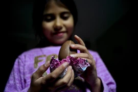 Một em nhỏ thích thú mở quả trứng chocolate hiệu Kinder tại Santiago, Chile. (Ảnh: AFP/TTXVN)