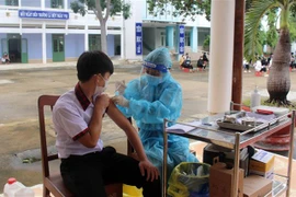 Học sinh Trường THPT Nguyễn Huệ, huyện Ninh Phước, tiêm vaccine phòng COVID-19 mũi 1 tại trường. (Ảnh: Công Thử/TTXVN)
