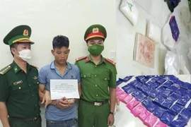 Lực lược chức năng bắt giữ Lò Văn Hiện cùng tang vật. (Ảnh: TTXVN)